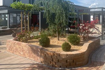 Neu gestaltete Gartenbau Ausstellung mit Trockenmauern und schöner Bepflanzung am Standort von Friede Bauzentrum.